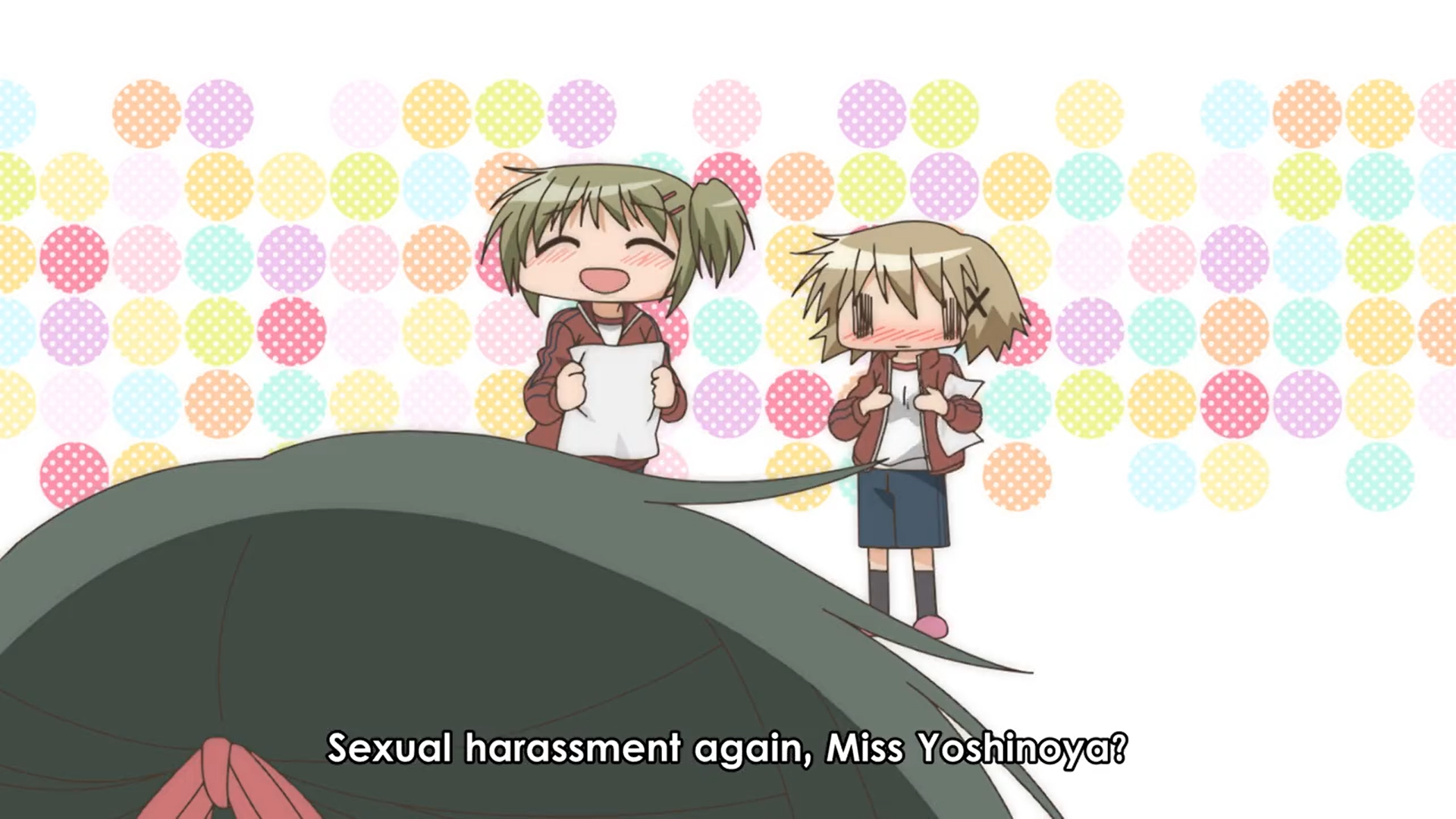 On the right, a girl blushing while touching her chest; on the left a girl holding papers, speaking to a third character, "Sexual harassment again, Miss Yoshinoya?"