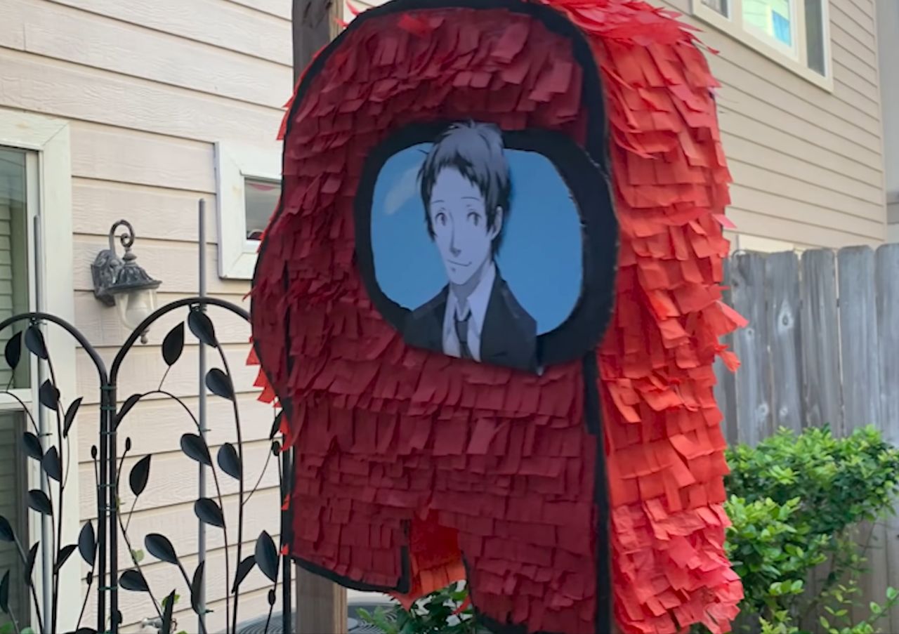 Among Us crewmate piñata with a picture of Adachi from Persona 4 taped to it
