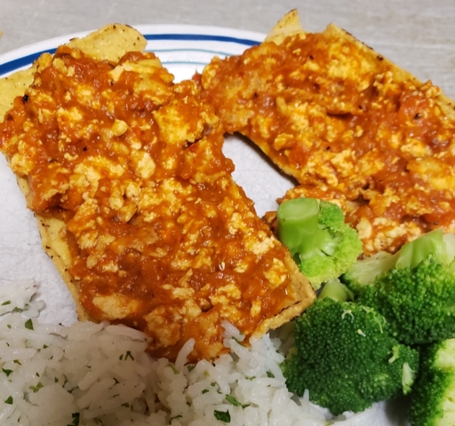 Tofu sofritas in tortilla boats on a white plate with a side of cilantro lime rice and steamed broccoli florets